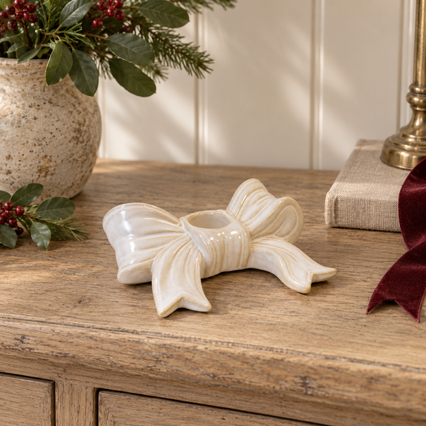 White Bow Ceramic Dinner Candle Holder styled with a lit dinner candle