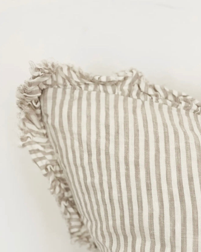 Natural beige square cushion cover with pinstripe pattern, soft furnishings by Ellenvale Trade, shown on a sofa.