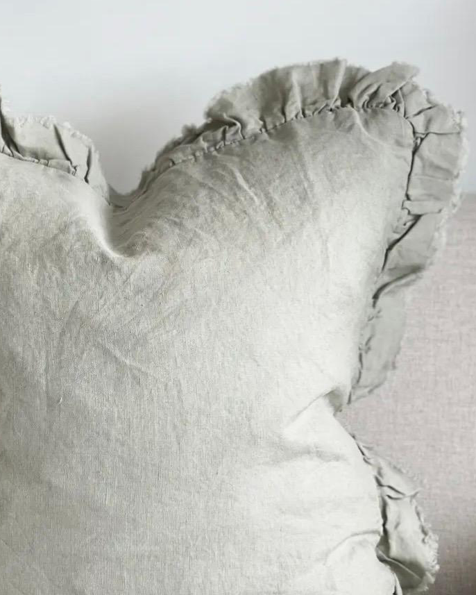 Sage green linen cushion cover with ruffled edges, soft furnishings by Ellenvale Trade, displayed on a decorative cushion.