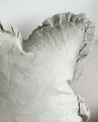 Sage green linen cushion cover with ruffled edges, soft furnishings by Ellenvale Trade, displayed on a decorative cushion.