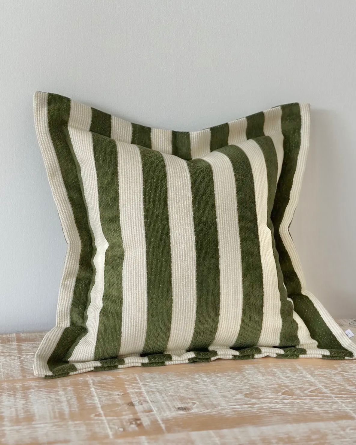 Olive green stripe cushion cover from Ellenvale Trade, soft furnishings with a modern striped design, close-up of fabric texture.