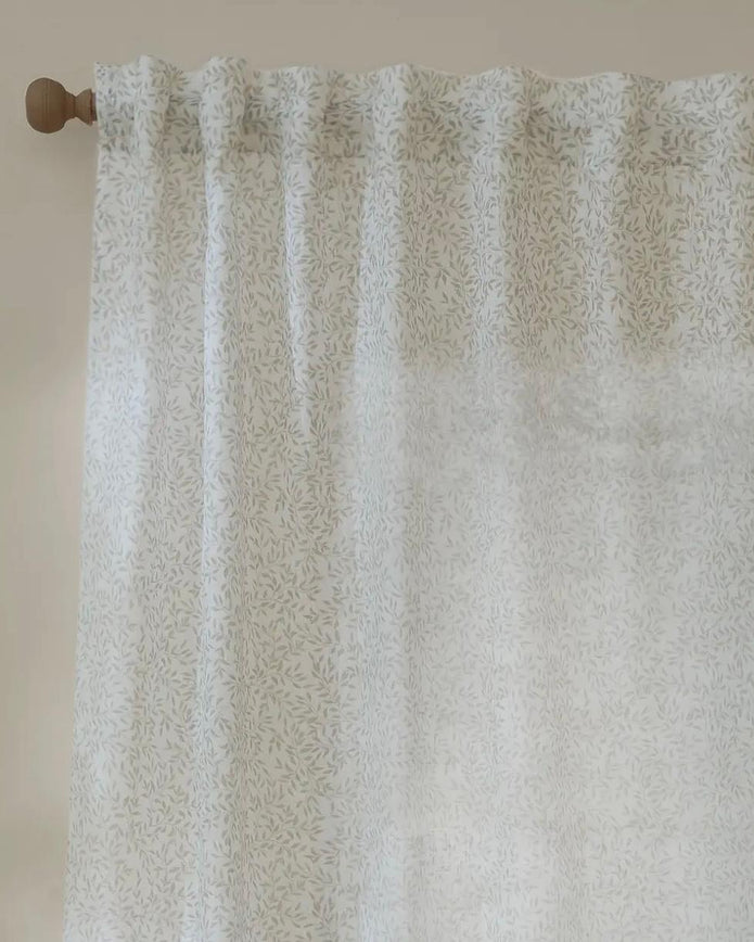 Natural woven voile curtain panel with yard leaf pattern, soft sheer fabric from Riva Home, ideal for light and airy window decor.