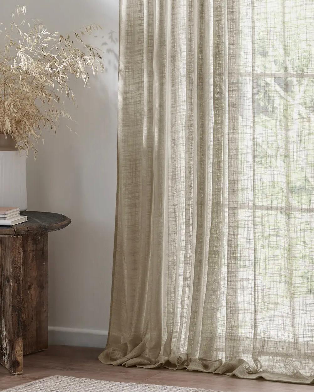 Riva Home Yard Natural woven sheer voile curtain panel hanging with soft light filtering through.