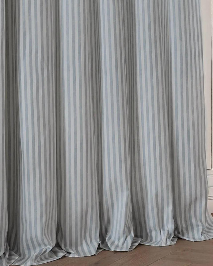 Ocean blue and black striped blackout eyelet curtains from Riva Home, showcasing soft furnishings with stylish eyelet tops.