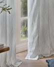 Riva Home Yard Ocean Blue striped blackout eyelet curtains hanging in a window, soft furnishings with bold blue and black stripes.