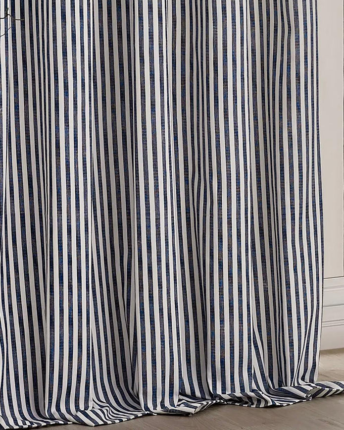 Navy blue and black striped blackout eyelet curtains by Riva Home hanging in a living room window, soft furnishings for privacy and style.