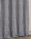 Navy blue and black striped blackout eyelet curtains by Riva Home hanging in a living room window, soft furnishings for privacy and style.