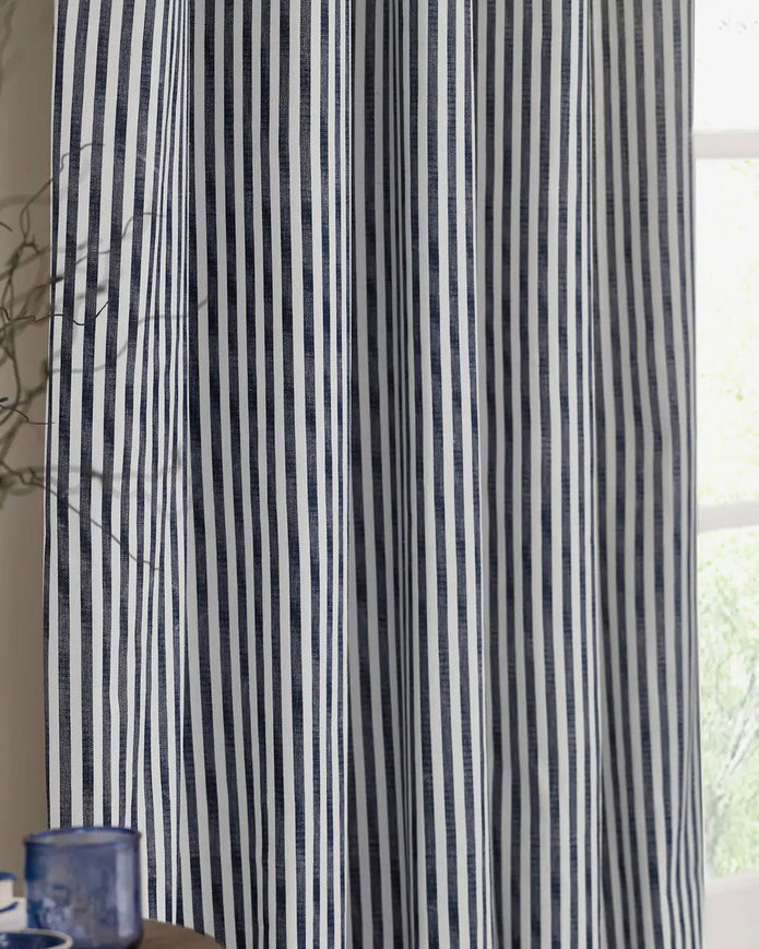 Navy blue and black striped blackout eyelet curtains from Riva Home, soft furnishings with a modern striped design and eyelet top.