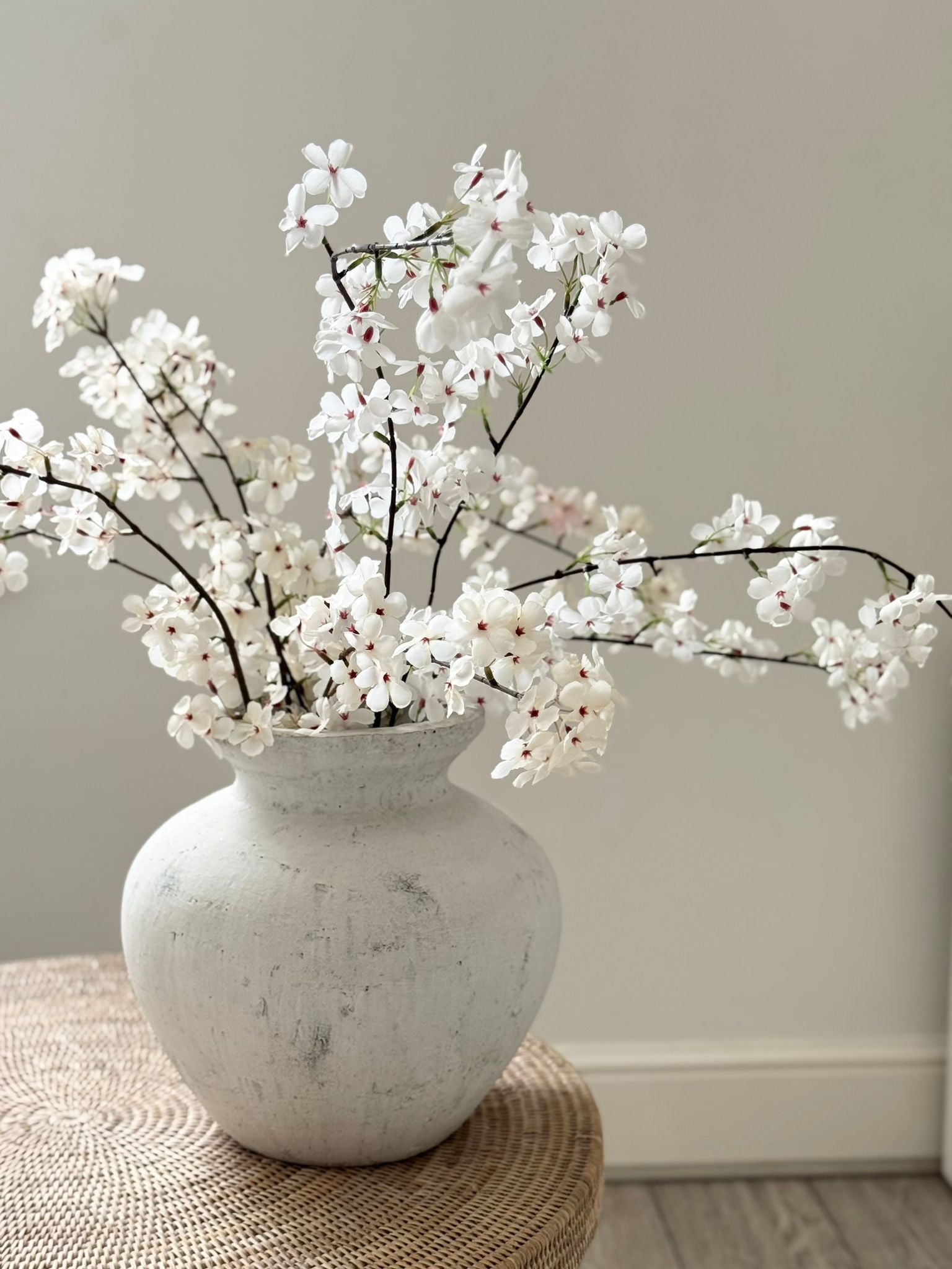 Artificial tall white cherry blossom stem from Starlight Express, showcasing delicate blossoms and green stems for decorative use.