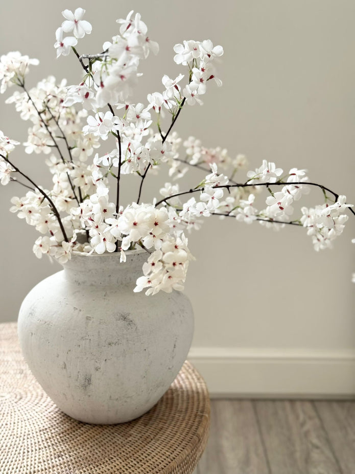 Artificial tall white cherry blossom stem from Starlight Express, showcasing delicate blossoms on a slender stem for decorative use.