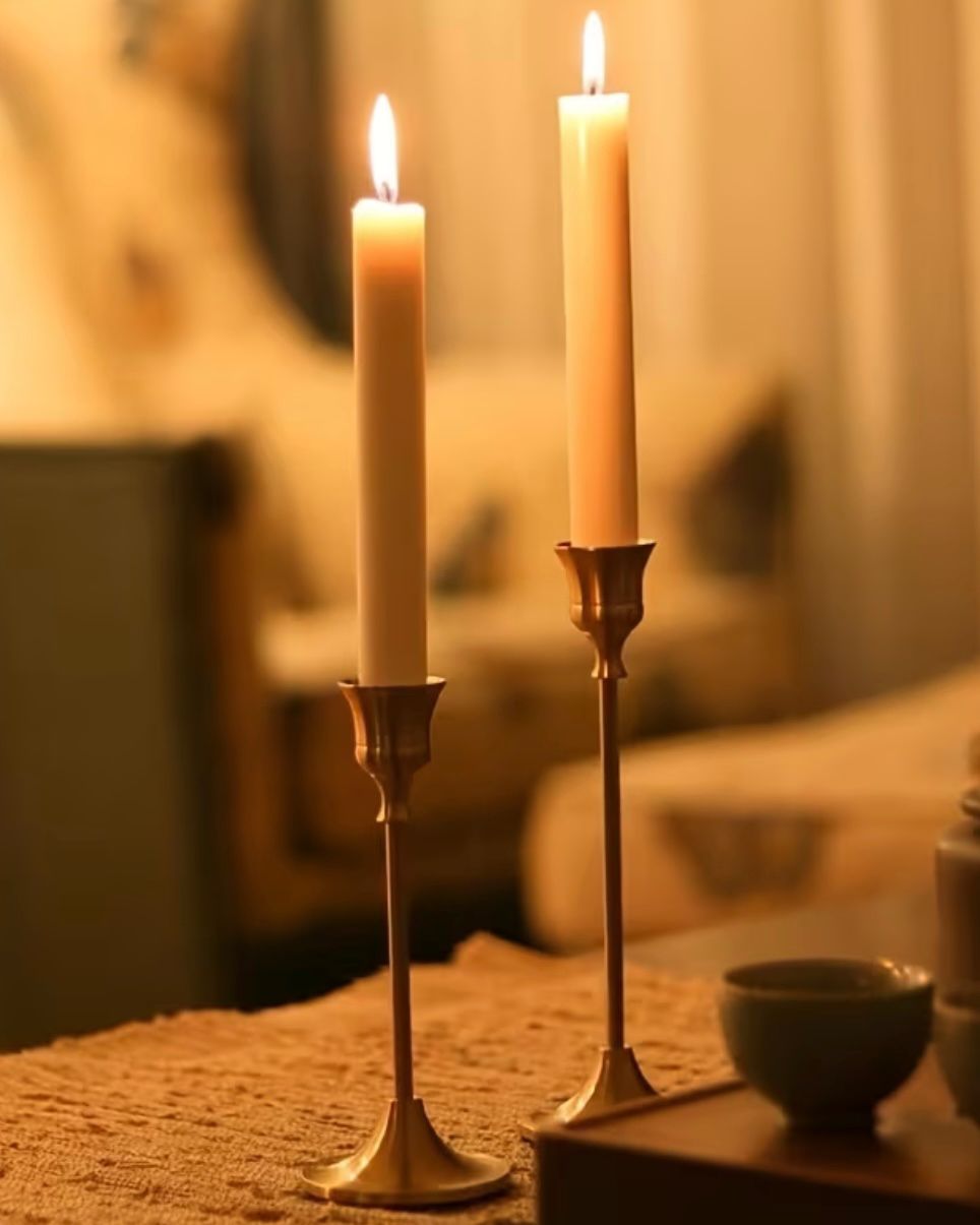 Antique brass effect taper candlestick as a home decor piece, featuring a classic design with a sturdy base and candle holder.