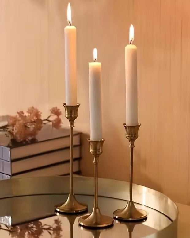 Antique brass effect taper candlestick for home decor, featuring a classic design with a polished brass finish.
