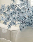 Artificial Ocean Blue Blossom Stem from Starlight Express, showcasing vibrant blue flowers and realistic green leaves.