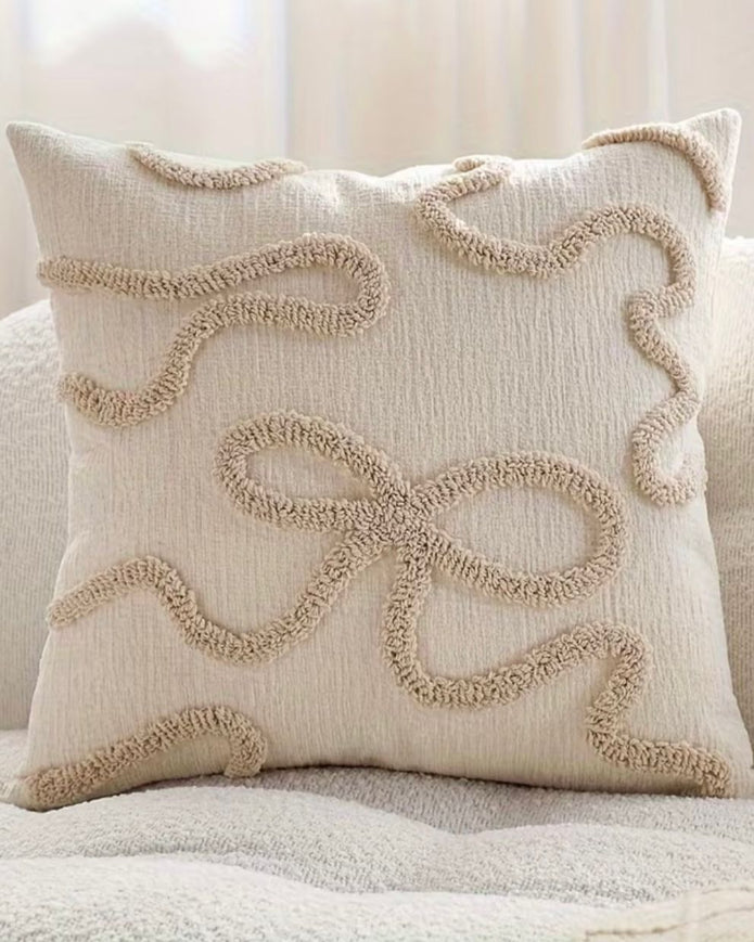 Cream and beige bow square boucle cushion cover from Starlight Express with soft, textured fabric and decorative bow detail.