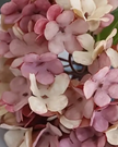Artificial pink hydrangea stem from Starlight Express, showing realistic short pink flower clusters and green foliage.