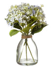 Artificial pale blue flower arrangement in a clear glass vase by Heaven Sends, showcasing delicate blooms and lush greenery.