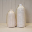 White leaf-patterned ceramic vase with a glossy finish and narrow bottle-shaped neck