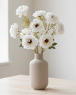 Artificial white and neutral poppy flower stem from Starlight Express, featuring realistic blooms and green foliage.