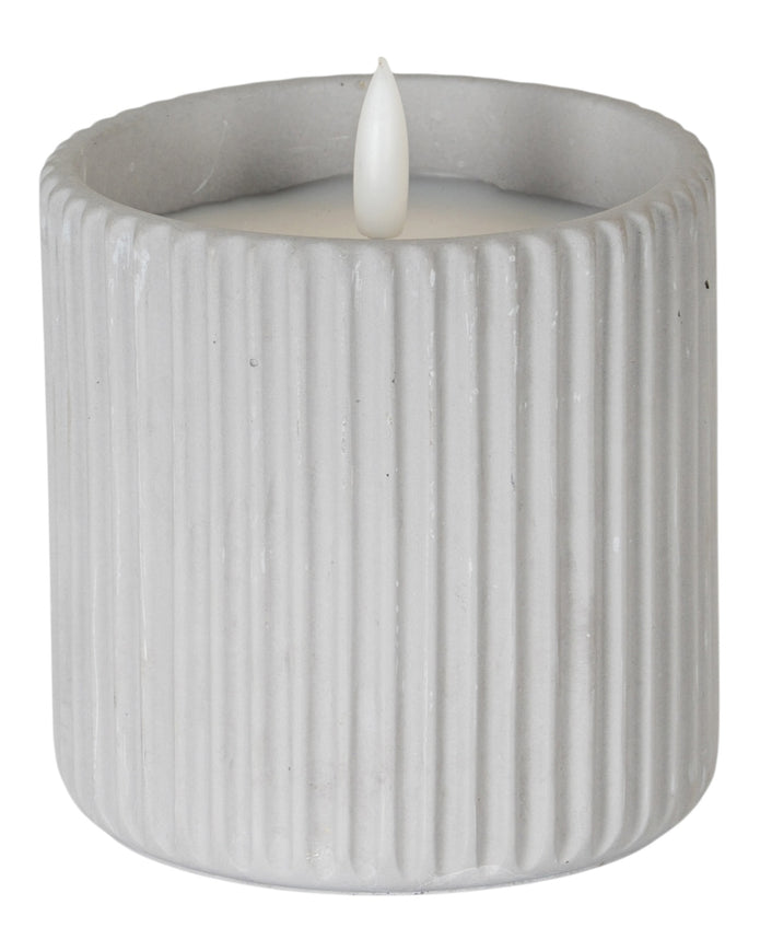 Natural stone ribbed LED candle for home decor by Hill Interiors, illuminated with a soft, warm glow in a stylish design.