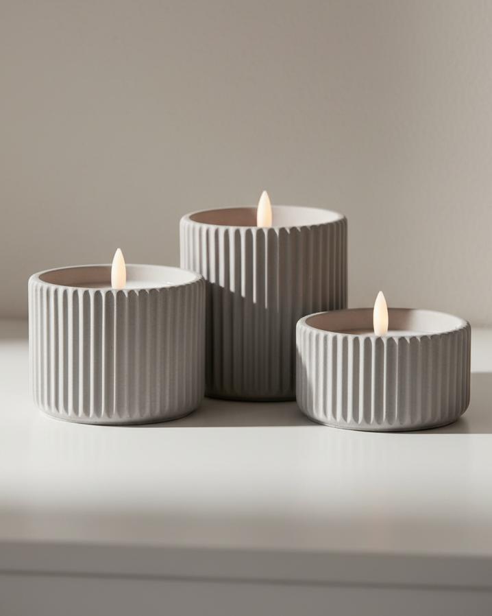 Ribbed natural stone LED candle from Hill Interiors, glowing softly for elegant home decor ambiance.