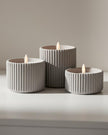 Ribbed natural stone LED candle from Hill Interiors, glowing softly for elegant home decor ambiance.
