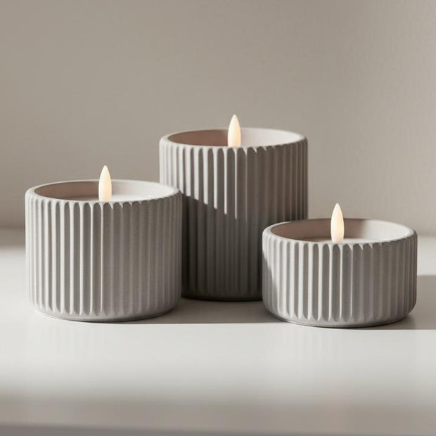 Ribbed natural stone LED candle from Hill Interiors, glowing softly for elegant home decor ambiance.