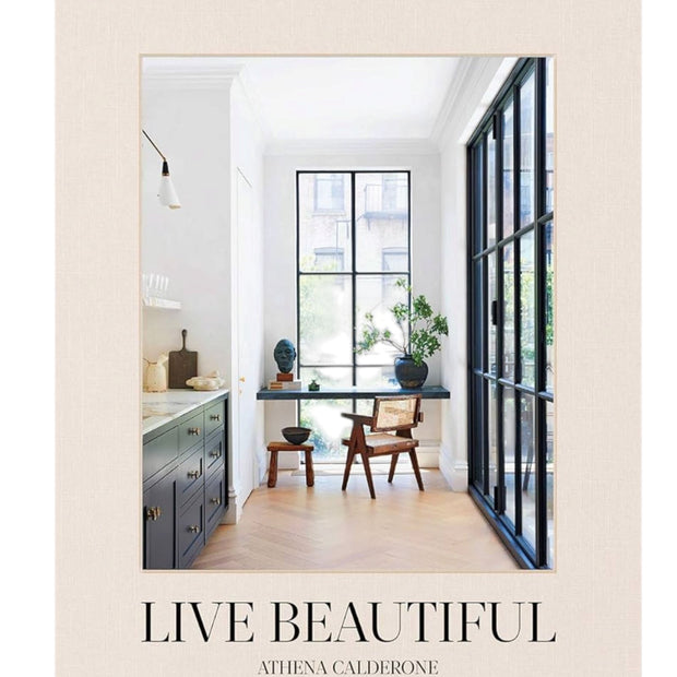 Open coffee table book titled "Live Beautiful" by Abrams & Chronicle Books, showcasing colorful interior design and lifestyle images.