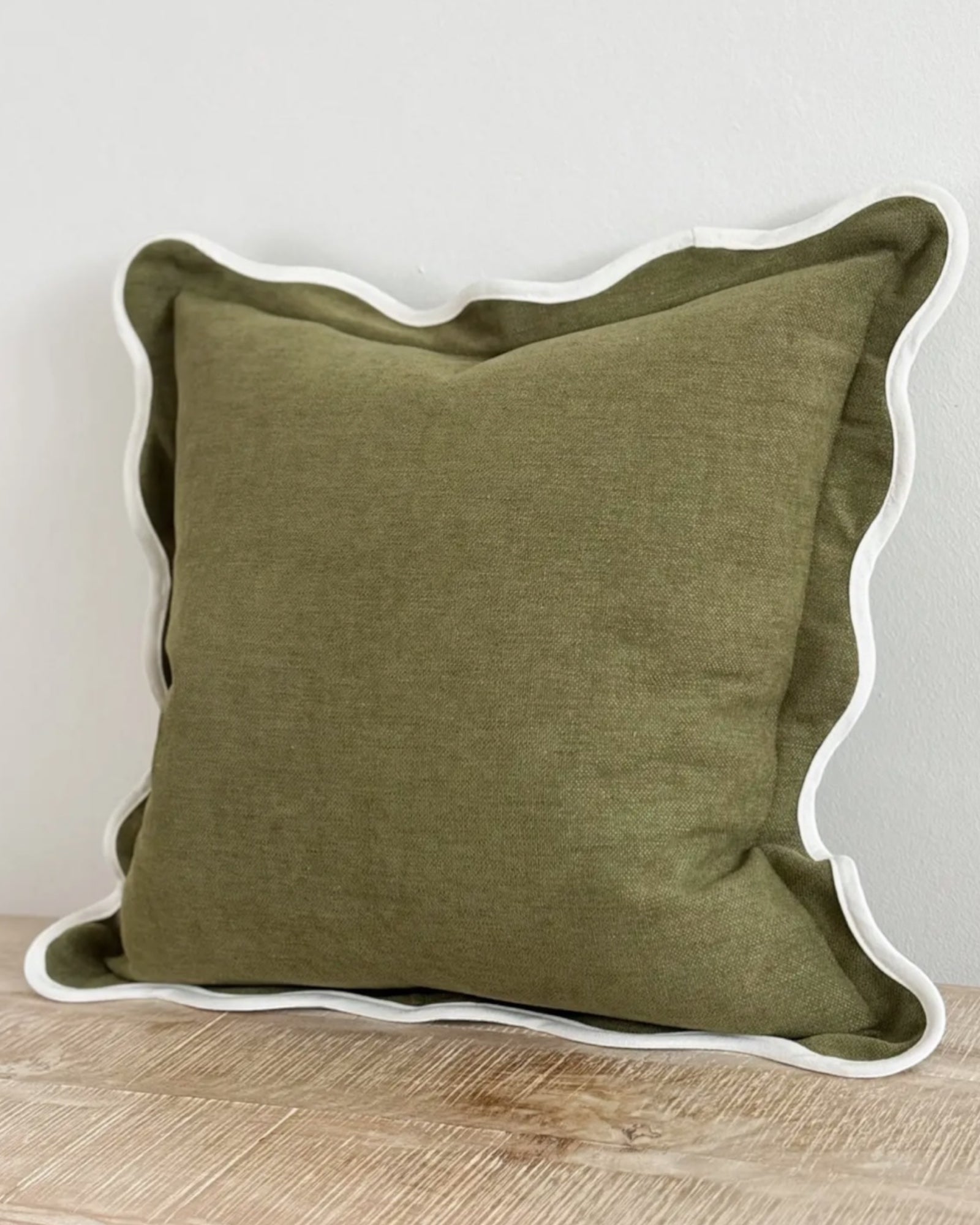 Olive green square cushion cover with scalloped edges, soft furnishings from Ellenvale Trade, showcasing intricate stitching and fabric texture.