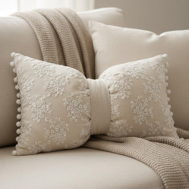 Cream neutral lace bow cushion from Starlight Express, soft furnishings with delicate lace detailing and plush fabric.