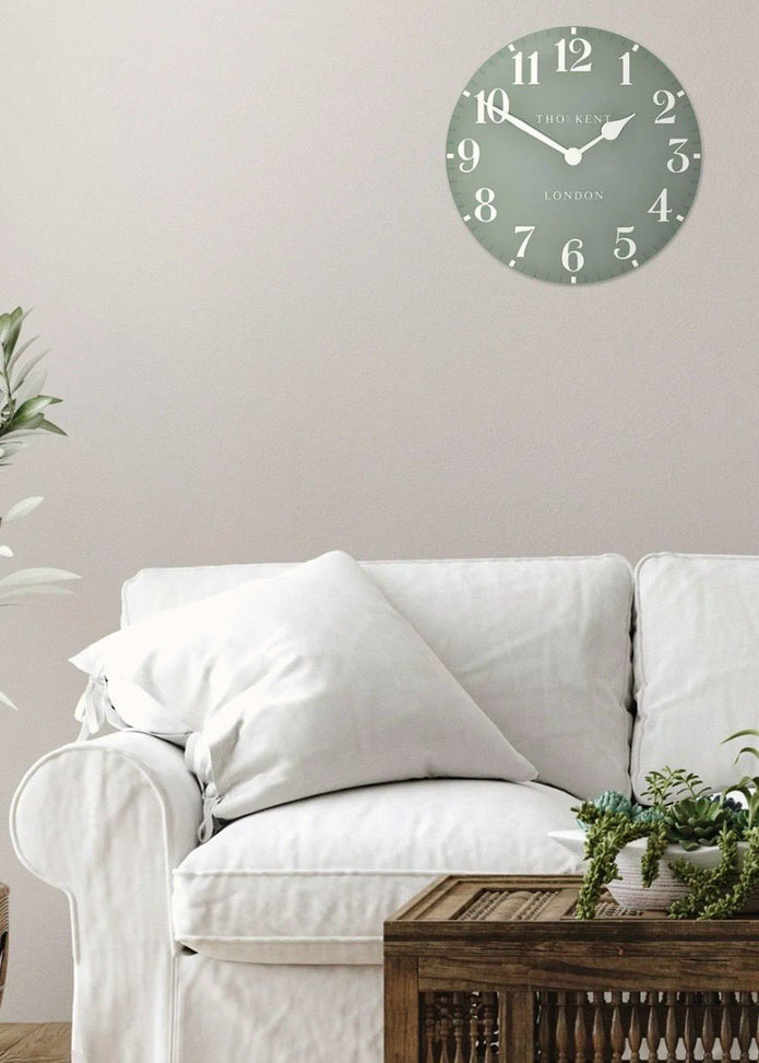 Thomas Kent 12-inch Arabic wall clock in seagrass green with black numerals, mounted on a plain wall.