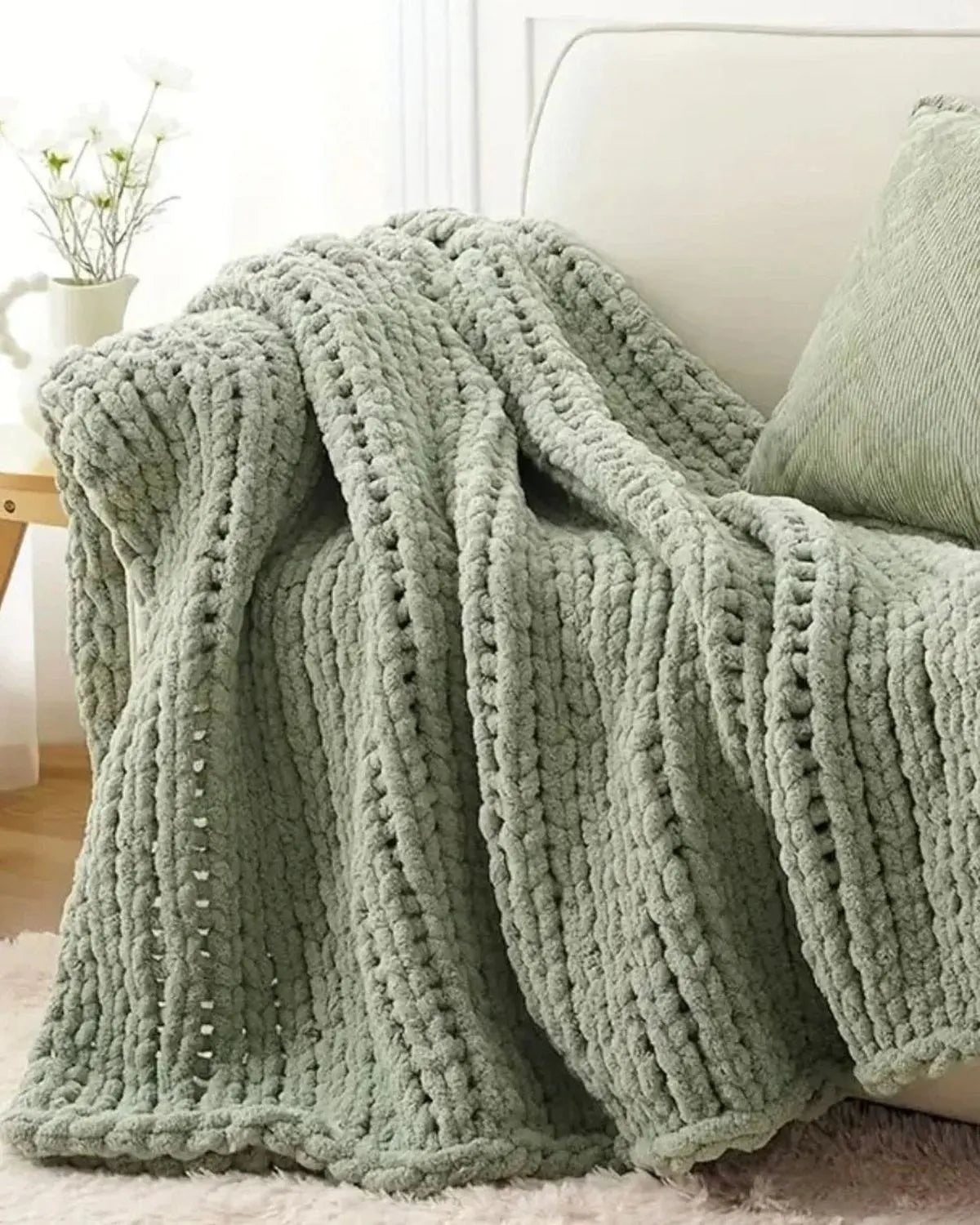 Soft sage green chunky chenille knit throw blanket by Starlight Express, showcasing its cozy, textured fabric and plush appearance.