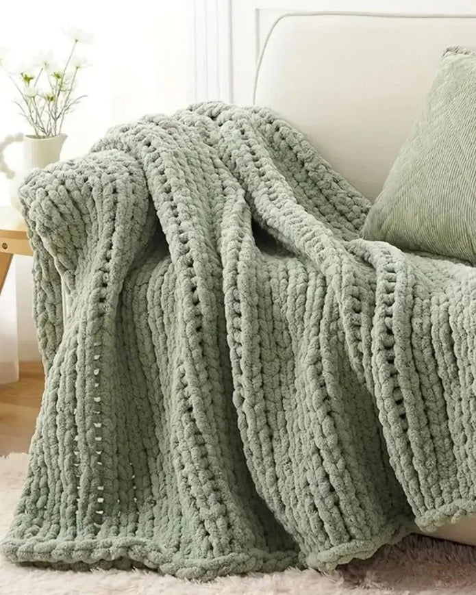 Soft sage green chunky chenille knit throw blanket by Starlight Express, showcasing its cozy, textured fabric and plush appearance.