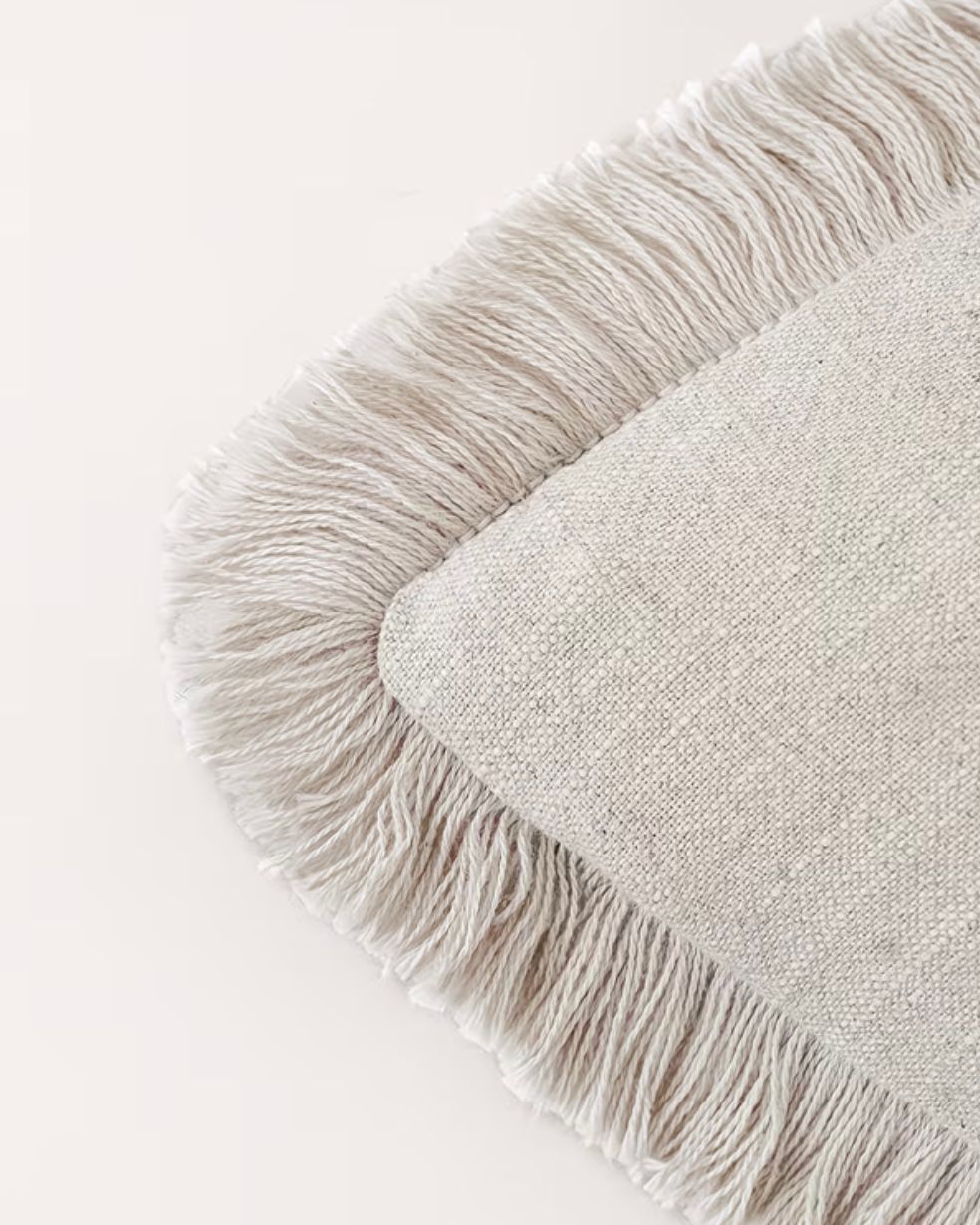 Starlight Express neutral cushion cover with frayed edge detail, made of soft furnishings fabric, displayed on a neutral background.