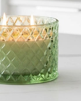 Green embossed glass candle with Corsia scent from Candlelight Products Ltd, showcasing the decorative textured glass container.