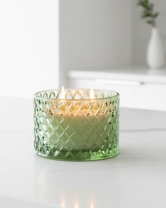 Embossed green glass candle with Corsia scent by Candlelight Products Ltd, decorative candle for ambient lighting.