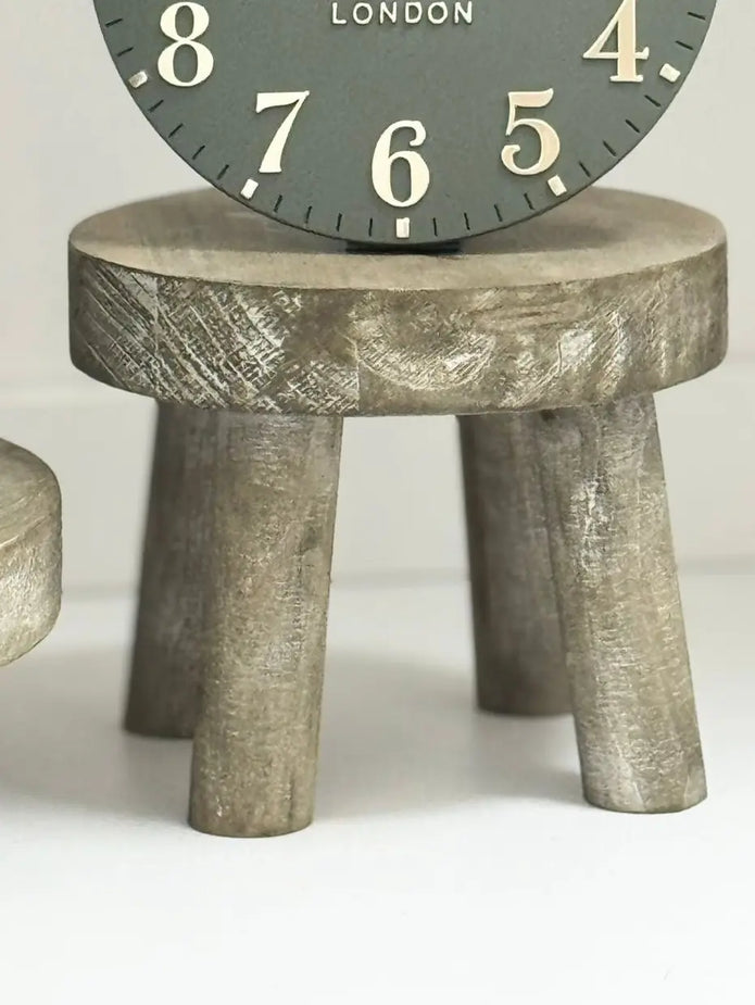 Gisela Graham wooden display milking stool used as rustic home decor piece, showcasing natural wood finish and simple design.