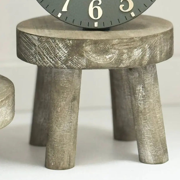 Gisela Graham wooden display milking stool used as rustic home decor piece, showcasing natural wood finish and simple design.