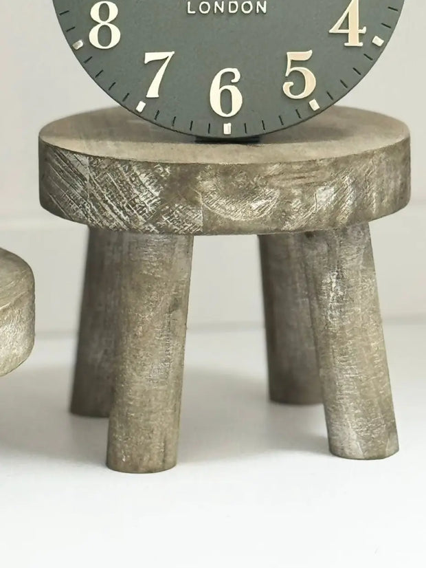 Gisela Graham wooden display milking stool used as rustic home decor piece, showcasing natural wood finish and simple design.