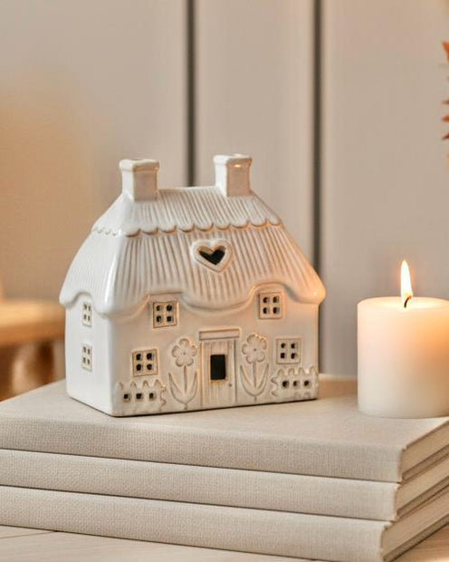 Natural Ceramic Thatch Roof House For Tealight, cream thatched-roof house lantern glowing beside a candle