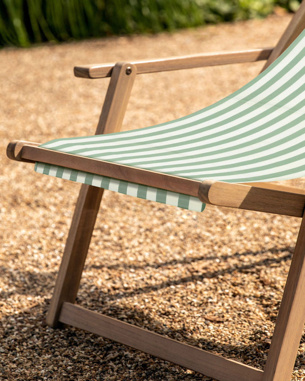 Sage green Creta wooden stripped garden chair by Gallery Direct, with a slatted wooden design and curved armrests.