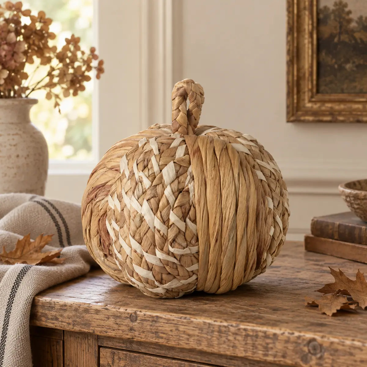 Natural plaited rattan pumpkin styled on an aged oak console