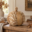 Natural plaited rattan pumpkin styled on an aged oak console