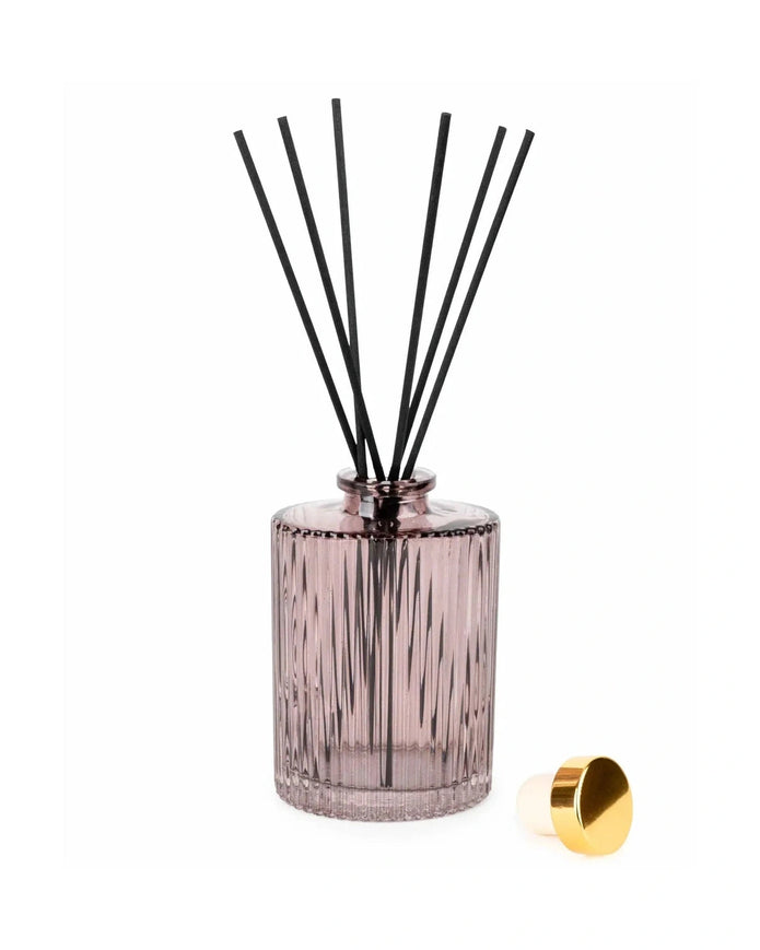 Diffuser bottle with black sticks and gold cap on a white background