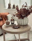 Round woven coffee table with decorative items in a cozy living room.