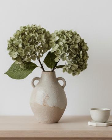 Artificial short sage green hydrangea stem from Starlight Express, showcasing realistic green blossoms and leafy stems.