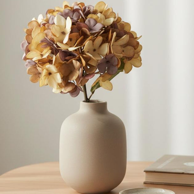 Artificial short dusky apricot hydrangea stem from Starlight Express, showcasing vibrant apricot blossoms on a realistic plant stem.