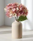 Artificial short pink hydrangea stem from Starlight Express, featuring vibrant pink blooms and green foliage for decorative use.