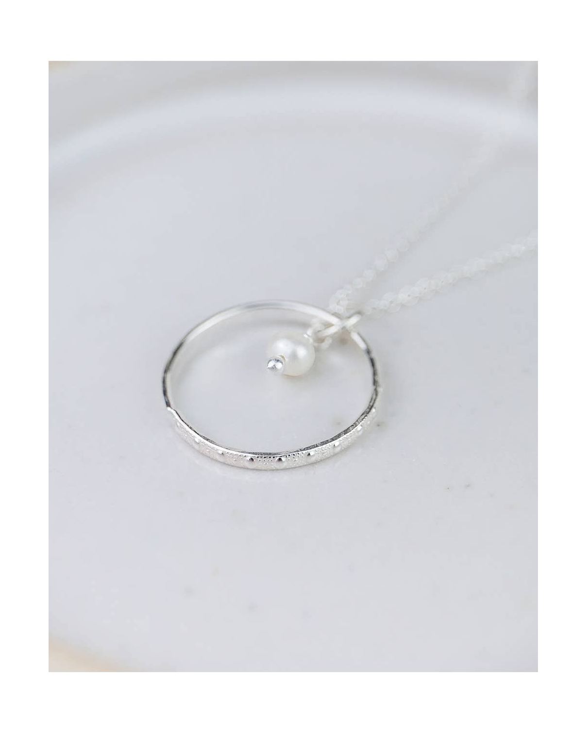 Silver ring with a pearl on a white dish