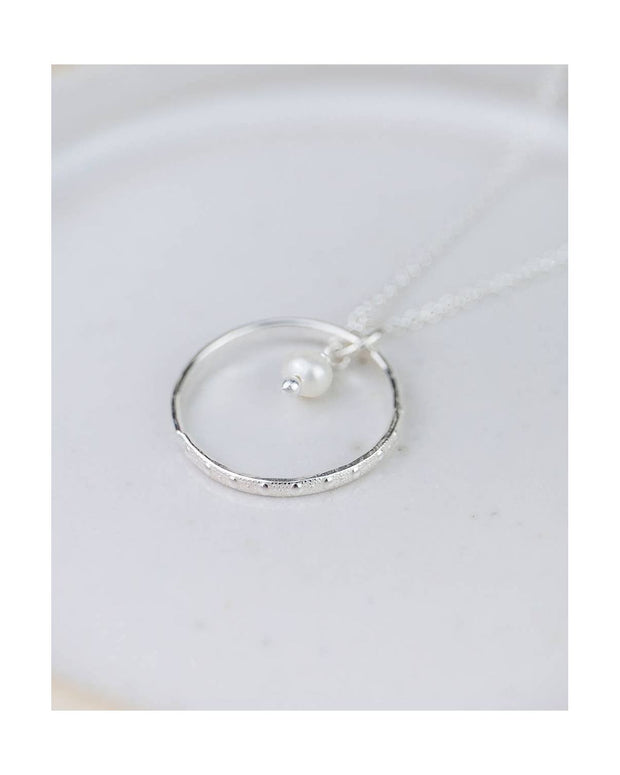 Silver ring with a pearl on a white dish