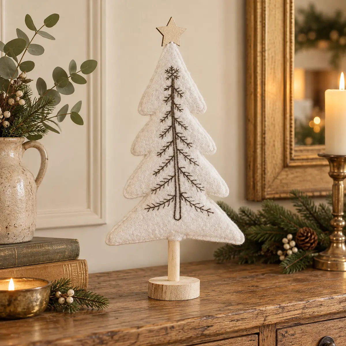 Tall white felt Christmas tree with gold star styled on an oak console
